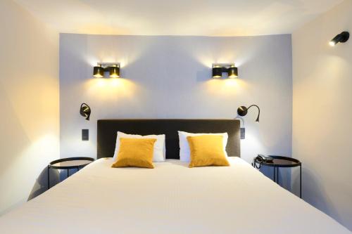 a bedroom with a large bed with two yellow pillows at Les Tanneurs in Namur