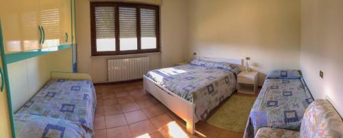 スペッロにあるAppartamenti Tomassiniのベッドルーム1室(ベッド2台、窓付)