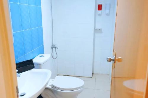 La salle de bains est pourvue de toilettes, d'un lavabo et d'une douche. dans l'établissement MMaple Residences Talisay, à Talisay