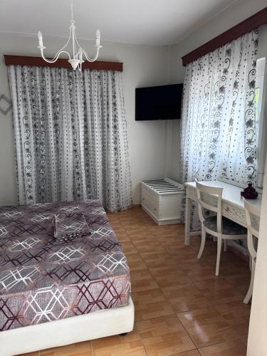 a bedroom with a bed and a table and a desk at Dionysia Studios in Kefalos