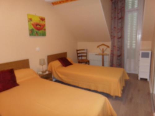 une chambre d'hôtel avec deux lits et une table dans l'établissement LE SELECT- BALAINE, à Néris-les-Bains