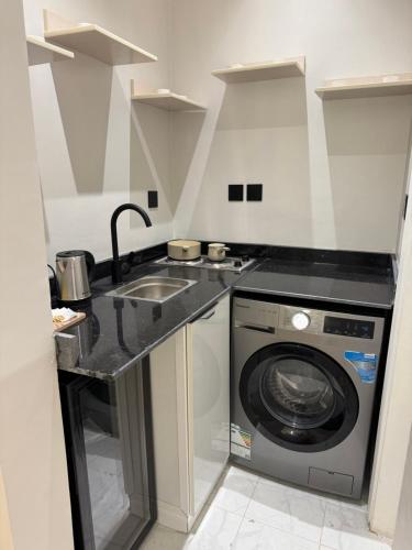een keuken met een wasmachine en een wastafel bij استديو متكامل بتصميم انيق in Riyad
