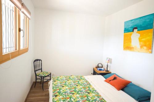 une chambre avec un lit et une chaise dans l'établissement Appartement Quadrille, à Lorgues