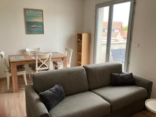 a living room with a couch and a table at La Teste cœur de ville in La Teste-de-Buch