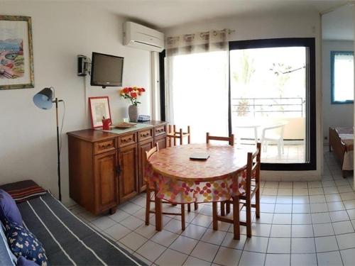 un salon avec une table, des chaises et une télévision dans l'établissement Appartement 2 Pièces Cabine 6 Pers. près Plage - Parking, Climatisation - FR-1-388-73, à Argelès-sur-Mer