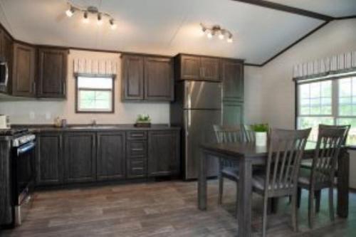 a kitchen with a table and chairs and a refrigerator at 2 Bedroom Cottage Maple Ridge 9 in Gravenhurst