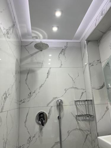 a bathroom with a shower with marble walls at Sweetmar guest Rooms-ground floor in Kos Town