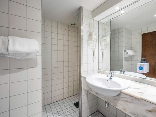 La salle de bains est pourvue d'un lavabo et d'un miroir. dans l'établissement Quality Hotel Maritim, à Haugesund