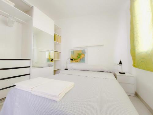 a white bedroom with a large white bed in it at Alojamiento Cartagena ático con terraza in Murcia