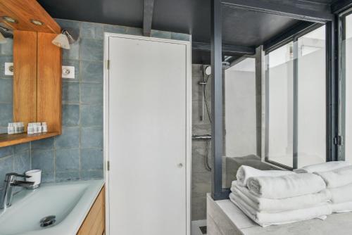une salle de bain avec une baignoire, un lavabo et un miroir dans l'établissement Atypique Loft 3 personnes with AC by Weekome, à Paris