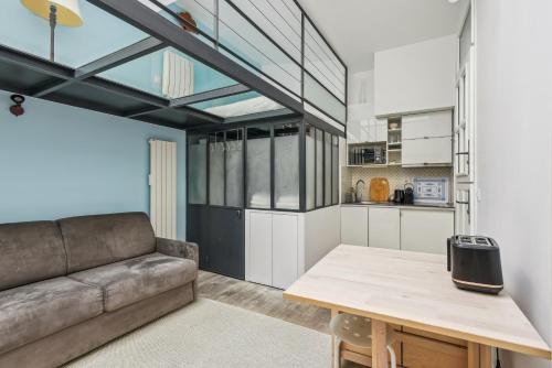 un salon avec un canapé et une table dans l'établissement Atypique Loft 3 personnes with AC by Weekome, à Paris