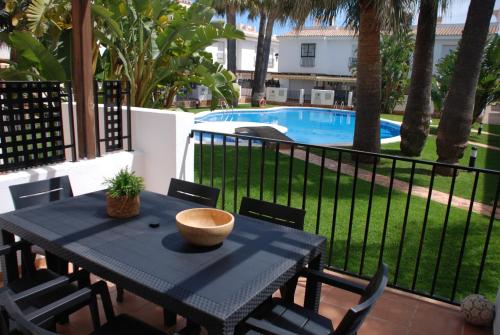 a black table with chairs and a bowl on top of it at Magnífico Adosado con Piscina en Urb. Palm Beach in Alcossebre