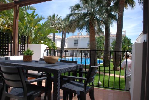 a patio with a table and chairs and a pool at Magnífico Adosado con Piscina en Urb. Palm Beach in Alcossebre