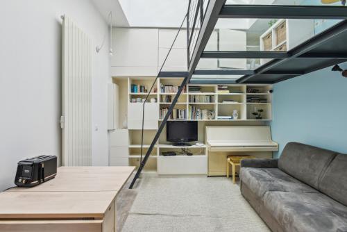 un salon avec un canapé et une table dans l'établissement Atypique Loft 3 personnes with AC by Weekome, à Paris