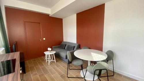 un salon avec une table, des chaises et un canapé dans l'établissement Appartement confortable proche Grands Boulevard 4P, à Paris