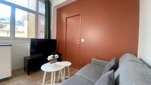un salon avec un canapé et une table dans l'établissement Appartement confortable proche Grands Boulevard 4P, à Paris