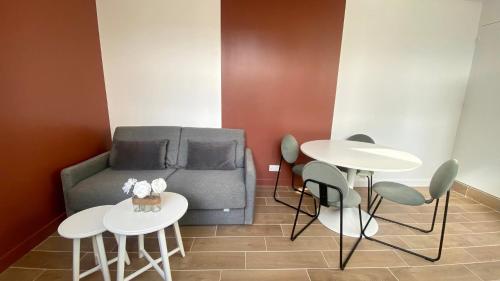 un salon avec un canapé et deux tables et chaises dans l'établissement Appartement confortable proche Grands Boulevard 4P, à Paris