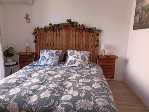 a bedroom with a large bed with a wooden headboard at " LE CHABASSOLE " CHAMBRES D'HÔTES - Massages - Jacuzzi - Sauna - GORGES DU VERDON in Aiguines