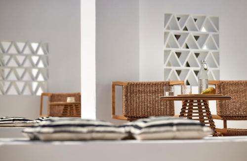 a table with wicker chairs and a table with at Enalion Suites Sifnos in Platis Yialos Sifnos