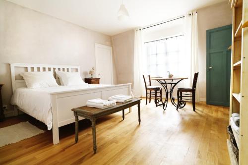 a bedroom with a bed and a table with chairs at La Bicyclette - Chambres d'hôtes in Chisseaux