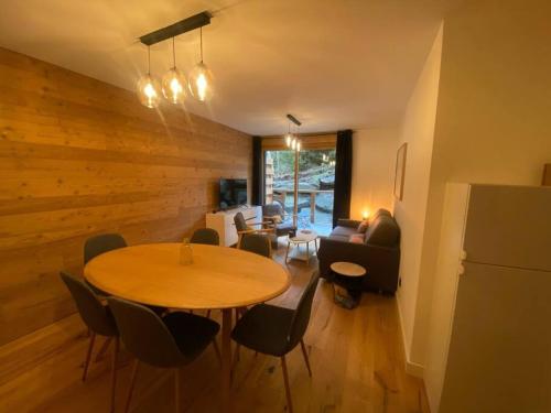 une chambre avec une table et des chaises ainsi qu'un salon dans l'établissement Appartement T2 de Standing Neuf 6-8 personnes avec Balcon et Jardinet au Pied des Pistes à Combloux, à Combloux