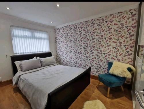 a bedroom with a bed and a blue chair at Woods view, central thornaby in Thornaby on Tees