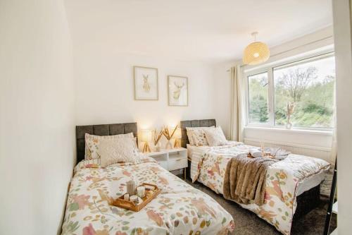a bedroom with two beds and a window at Serene Boho Retreat: White Oak Charm House 7ppl in Sheffield
