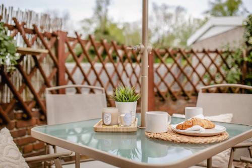 Serene Boho Retreat: White Oak Charm House 7ppl في شيفيلد: طاولة زجاجية مع طبق من الطعام على الفناء