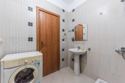 un bagno con lavatrice e lavandino di Orange Beachfront Studio by PS a Golem