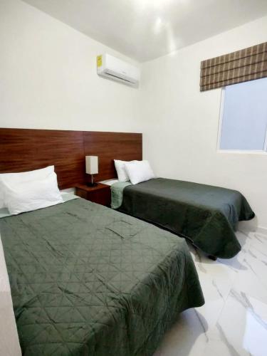Cette chambre comprend 2 lits et une fenêtre. dans l'établissement Departamento en tulum Quintana roo, à Tulum