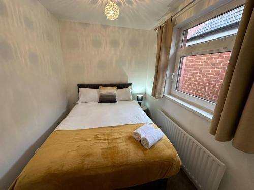 uma pequena cama num quarto com uma janela em 2br Stylish Ormeau Road House em Belfast