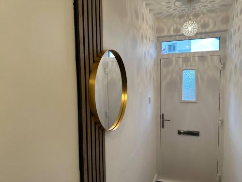 a mirror on a wall next to a door at 2br Stylish Ormeau Road House in Belfast