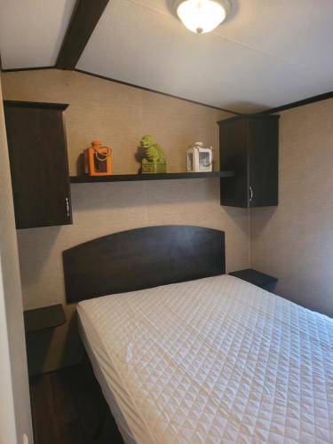 a bedroom with a bed and a shelf with a bedvisor at 3 Bedroom Cottage Beachview Lane 35 in Cherry Valley