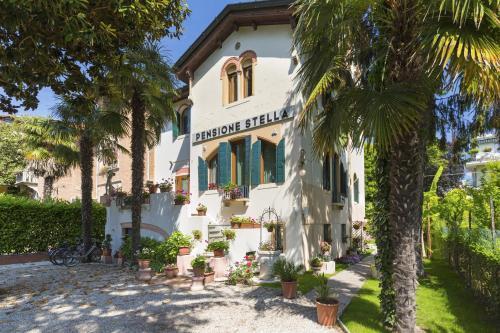 un edificio con palmeras delante en Hotel Villa Stella en Lido de Venecia