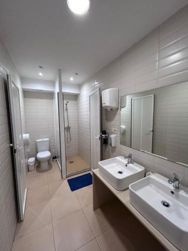 ein Bad mit einem Waschbecken, einer Dusche und einem WC in der Unterkunft Albergue Mar del Plata in Kap Finisterre