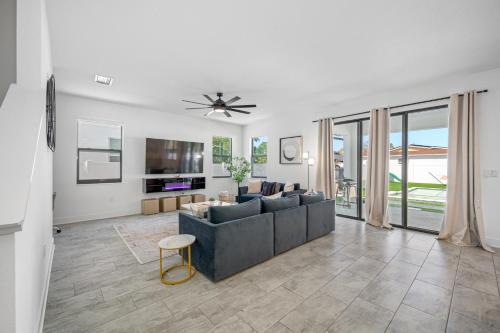 a living room with a couch and a ceiling fan at Luxury Modern Villa w Pool Jacuzzi Amenities in Tampa
