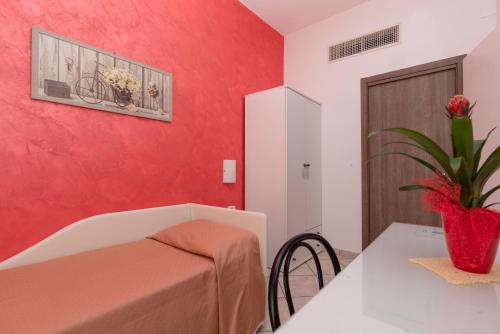 a room with a table and a red wall at Hotel Baia Verde in Maiori