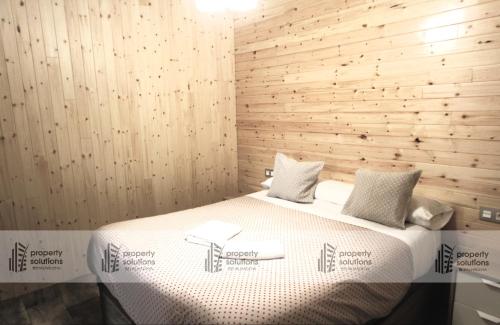 Carihuela Loft - Los Nidos - 2º LINEA DE PLAYA - Excelente conexión wifi في توريمولينوس: غرفة نوم بسرير مع جدار خشبي