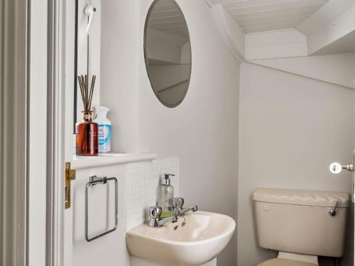 a white bathroom with a sink and a mirror at 1 An tSean Scoil, Clifden in Clifden