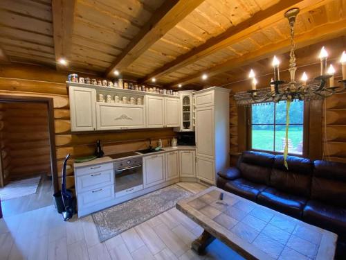 a kitchen with a couch and a table in a room at Poilsio namelis in Kaišiadorys