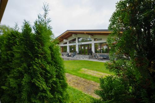 ein großes Gebäude mit einem Hof mit Bäumen davor in der Unterkunft Hotel Yara in Vişeu de Sus