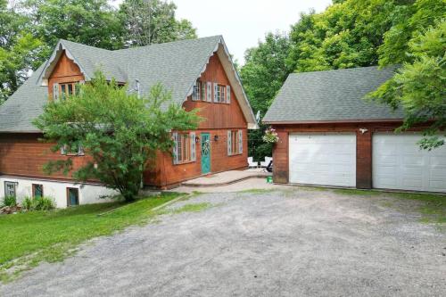 a house with a garage and a house at Chalet Mont Cascades w/ Spa & Fibre Optic Internet in Cantley