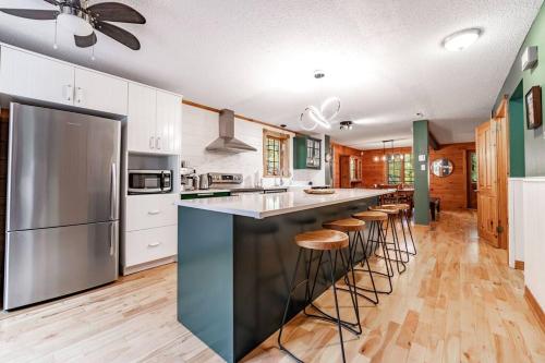 a kitchen with a large island with bar stools at Chalet Mont Cascades w/ Spa & Fibre Optic Internet in Cantley