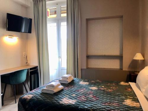 a hotel room with a bed with two towels on it at Hôtel Le Cro-Magnon in Les Eyzies-de-Tayac