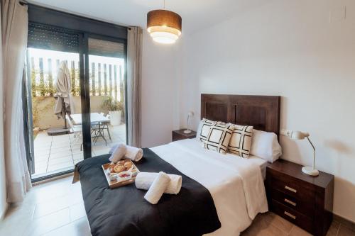 um quarto com uma cama grande e uma varanda em Apto con 2 terrazas,gym y piscina comunitaria em El Campello