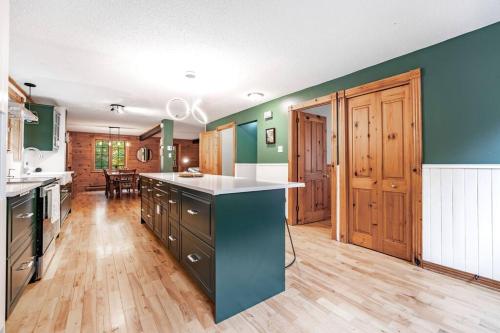 a large kitchen with a blue island in the middle at Chalet Mont Cascades w/ Spa & Fibre Optic Internet in Cantley