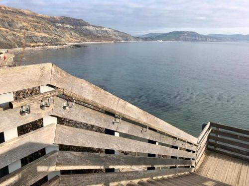 a bench on a pier overlooking a body of water at Bentley Rise in Lyme Regis