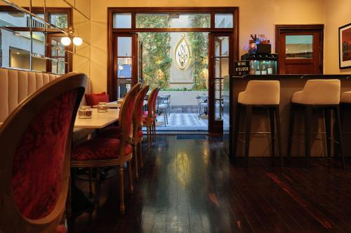 Miravida Soho Hotel & Wine Bar في بوينس آيرس: غرفة طعام مع طاولة وكراسي في مطعم