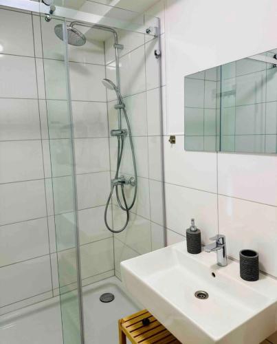 a bathroom with a sink and a glass shower at Zentral gelegenes und stilvoll möbliertes Apartment in Duisburg Nur 5 Minuten vom Hbf und City, ideal für Pendler und Messebesucher in Duisburg