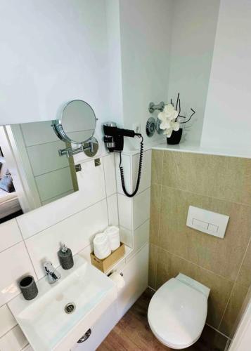 a bathroom with a sink and a toilet and a mirror at Zentral gelegenes und stilvoll möbliertes Apartment in Duisburg Nur 5 Minuten vom Hbf und City, ideal für Pendler und Messebesucher in Duisburg